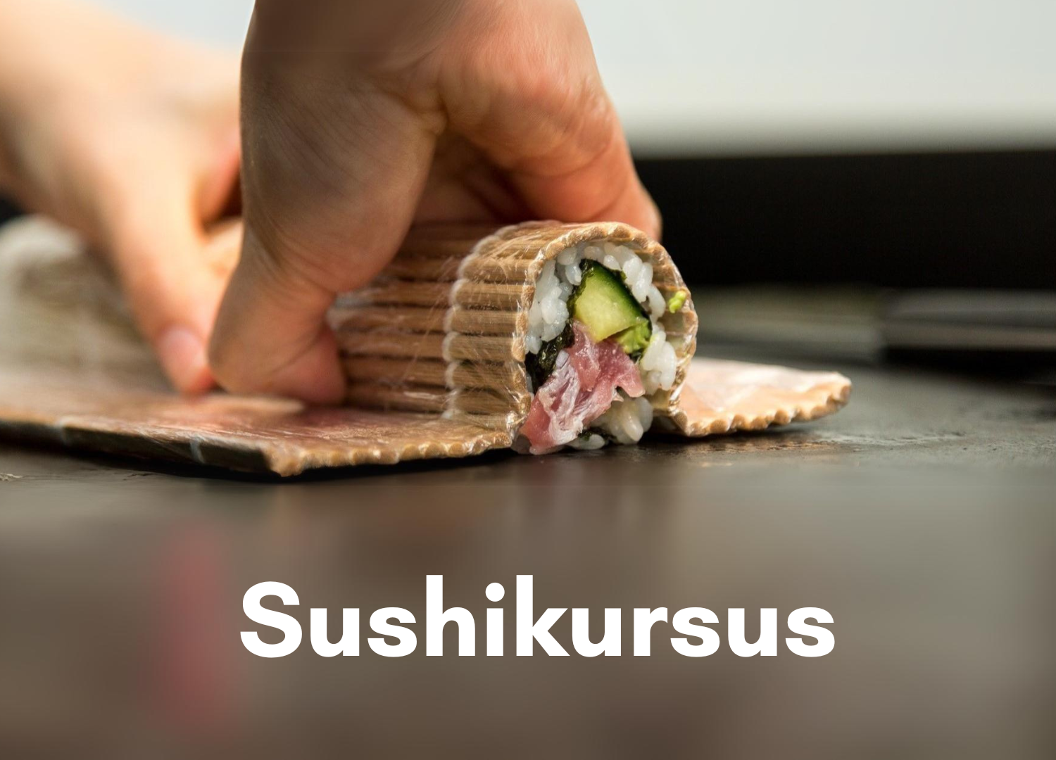 Et sæt hænder der er ved at rulle en sushi rulle